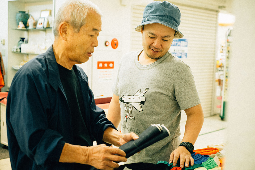 「デニムの生地、見さして下さいよ〜」と、松本さんが言うと、青木社長が軒先へと案内してくれた。